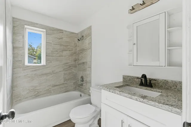 a view of an empty room with wooden floor and closet