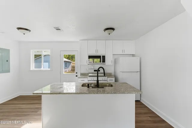 a bathroom with a granite countertop sink toilet and mirror