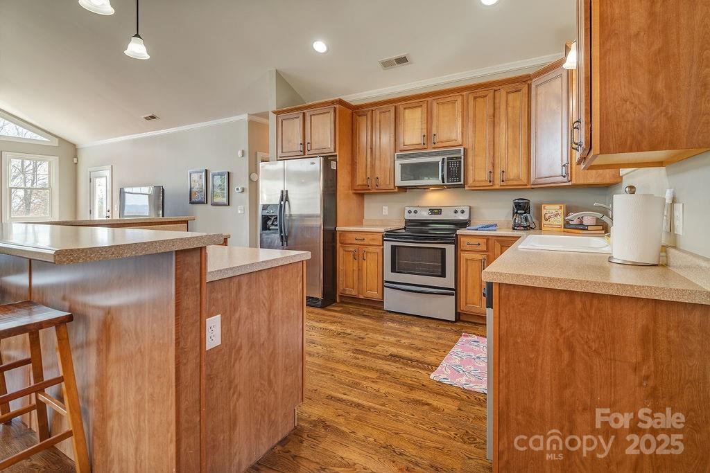 61 Buckle Ridge Weaverville, NC 28787 - Photo 11 of 42 a kitchen with stainless steel appliances granite countertop a stove top oven a refrigerator a sink and dishwasher with wooden floor