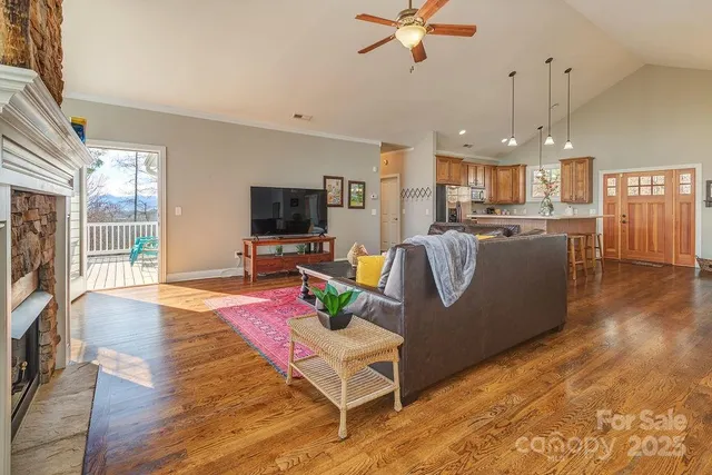 a living room with furniture kitchen view and a wooden floor