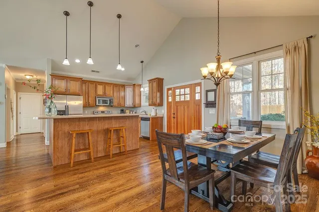 a view of a dining room and livingroom with furniture wooden floor a chandelier