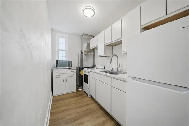 a kitchen with sink cabinets and stove top oven
