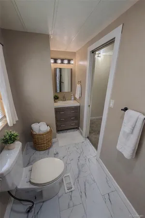 a bathroom with a toilet a sink and mirror
