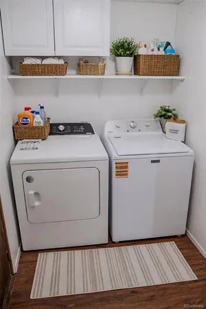a utility room with wooden floor washer and dryer