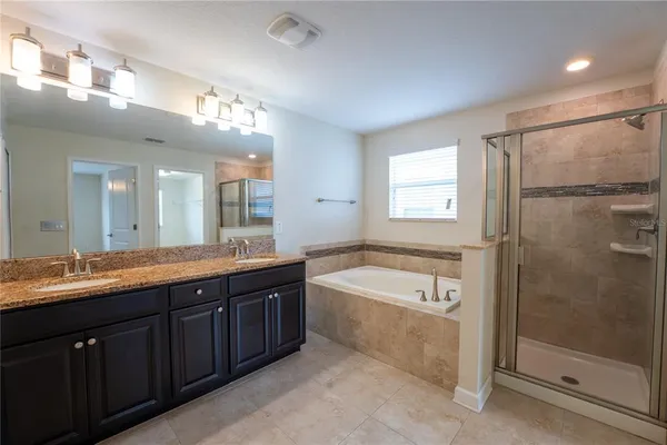 a spacious bathroom with a granite countertop tub sink and mirror