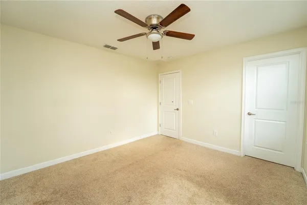 an empty room with a window and a ceiling fan