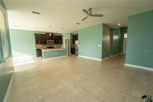 a kitchen with kitchen island stainless steel appliances granite countertop a sink counter space and cabinets