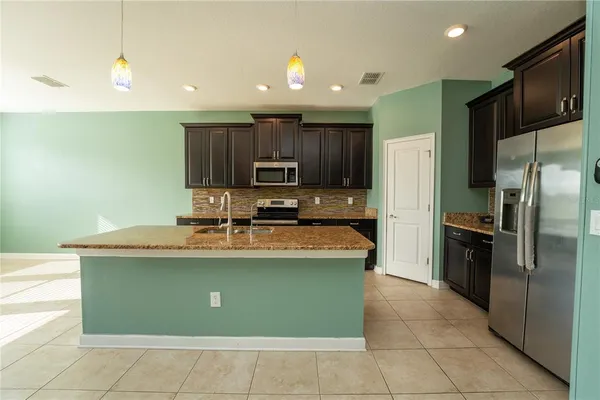 a large kitchen with stainless steel appliances granite countertop a sink and a stove