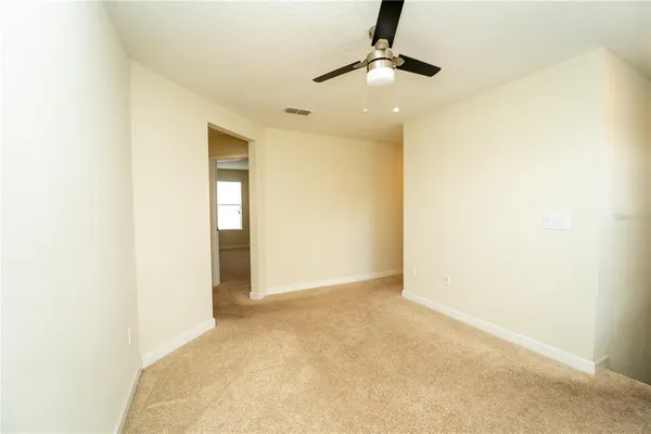 an empty room with a window and a ceiling fan