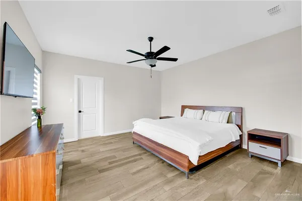 a bed sitting in a spacious bedroom next to a window