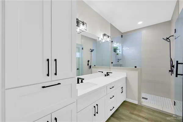 a bathroom with a double vanity sink mirror and shower