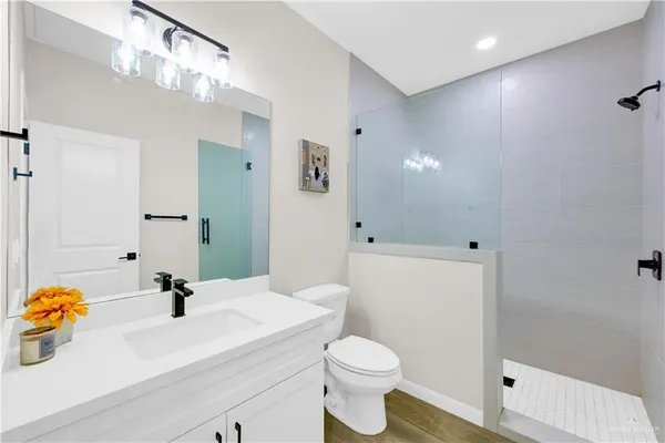 a bathroom with a sink a toilet and shower
