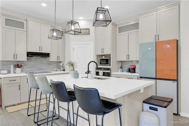 a kitchen with stainless steel appliances a table chairs and a refrigerator
