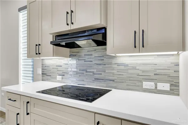 a kitchen with granite countertop white cabinets and white appliances
