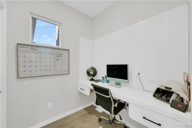a view of a workspace with furniture and wooden floor