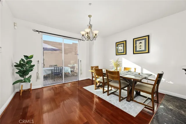 a dining room with furniture potted plants and wooden floor