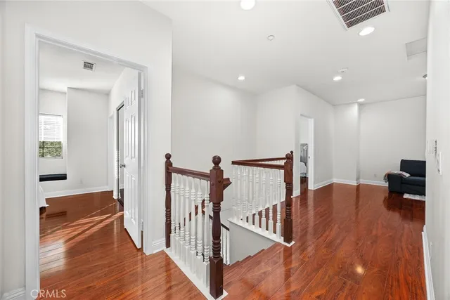 a view of a hallway with wooden floor and stairs