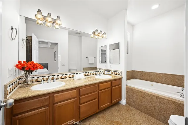a bathroom with a tub sink and mirror