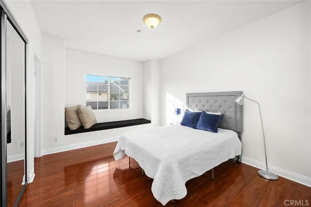 a bedroom with a bed and wooden floor