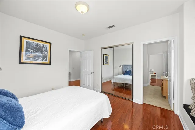 a bedroom with a large bed and wooden floor