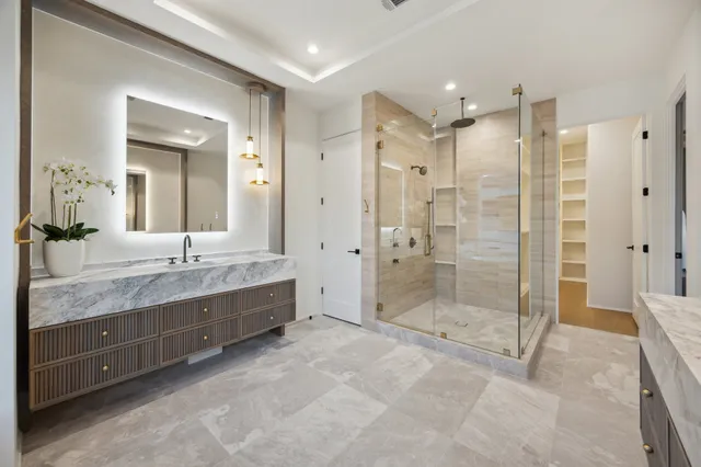 a bathroom with a granite countertop sink mirror shower and double