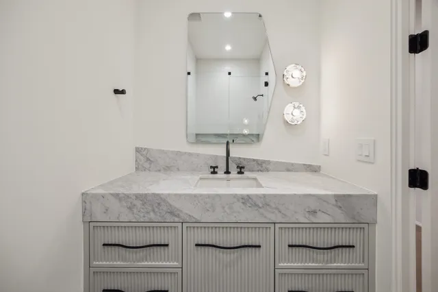 a bathroom with a granite countertop sink a toilet and a mirror