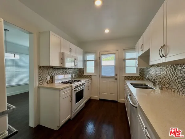 a kitchen with a stove sink and cabinets