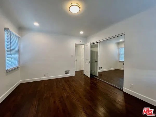 an empty room with wooden floor and closet
