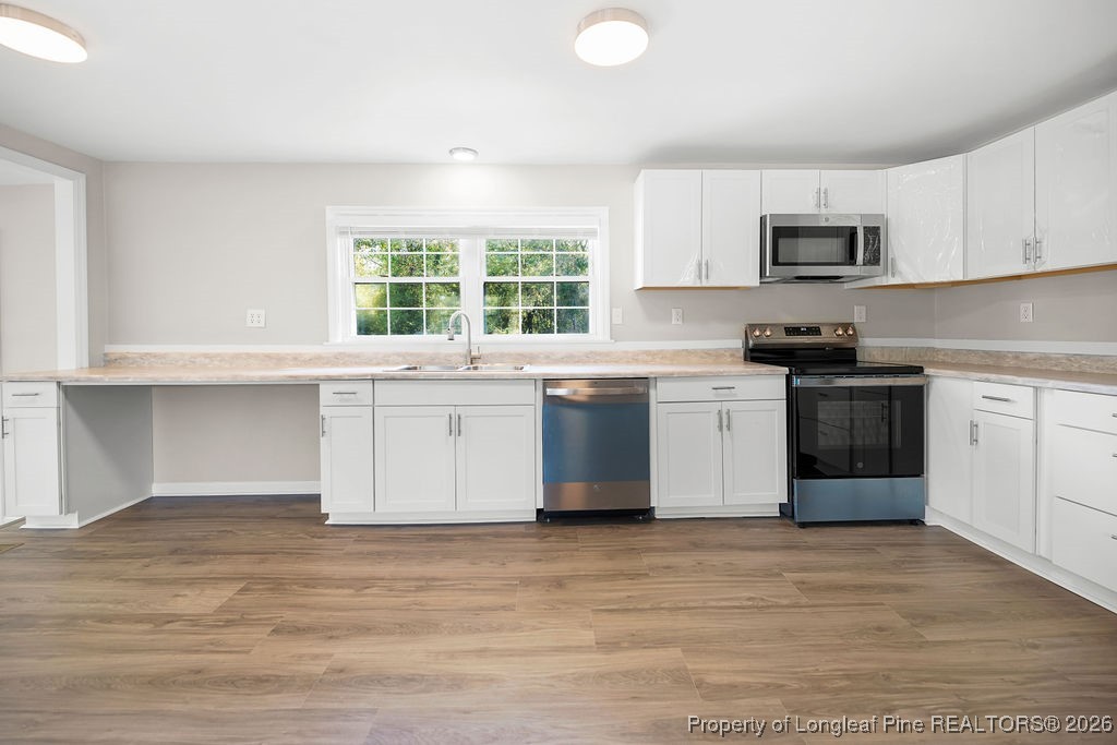 4066 Hummingbird Place Fayetteville, NC 28312 - Photo 11 of 30 a kitchen with stainless steel appliances granite countertop a stove and a sink