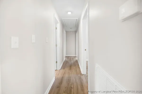 a view of a hallway with wooden floor