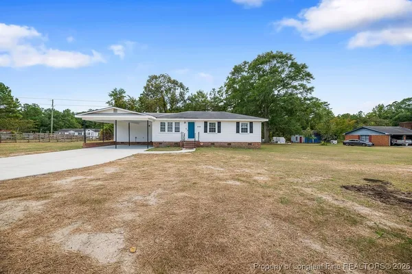 a view of a house with a yard and sitting area