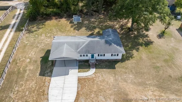 a aerial view of a house with a yard and large tree