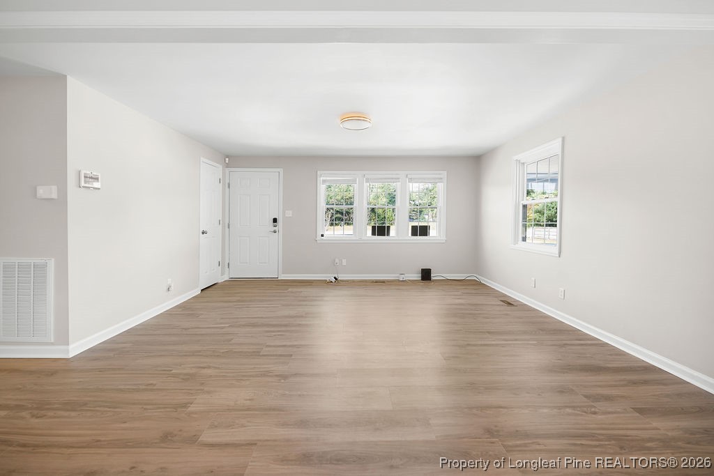 4066 Hummingbird Place Fayetteville, NC 28312 - Photo 6 of 30 an empty room with wooden floor and windows