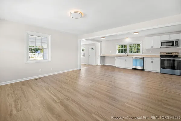 a view of open kitchen with wooden floor and electronic appliances