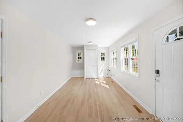 an empty room with wooden floor and windows