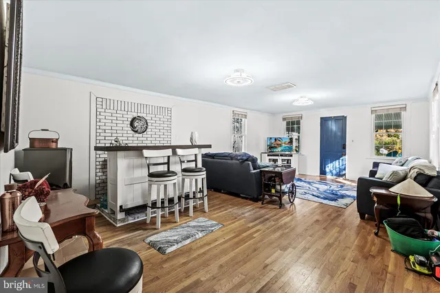 a living room with furniture a wooden floor and next to a window