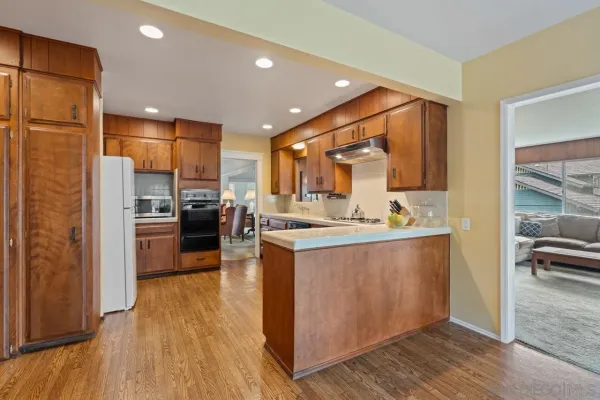 a kitchen with stainless steel appliances granite countertop a refrigerator a sink a stove and oven