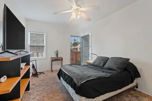 a bedroom with a bed and a flat tv screen on dresser