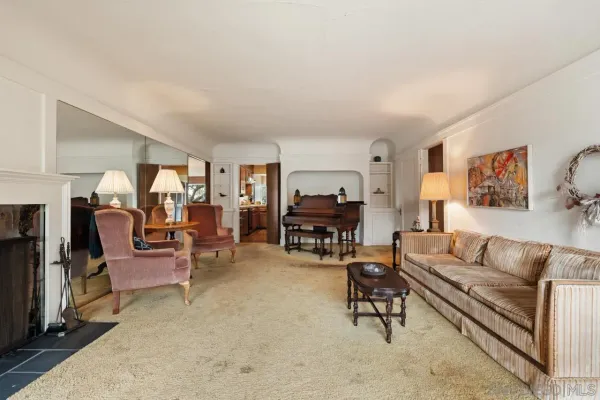 a living room with furniture and a dining table with wooden floor