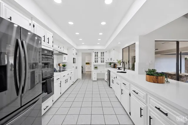 a large white kitchen with stainless steel appliances and white cabinets
