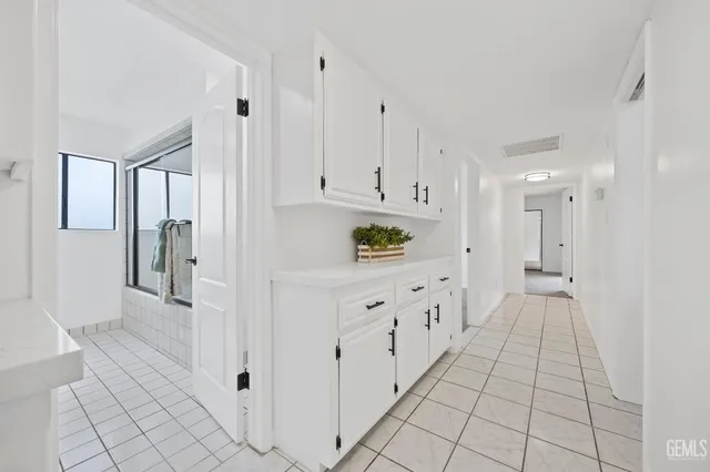 a kitchen with white cabinets and refrigerator