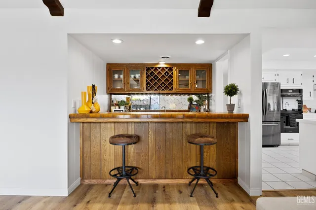 a kitchen with a sink a refrigerator and chairs