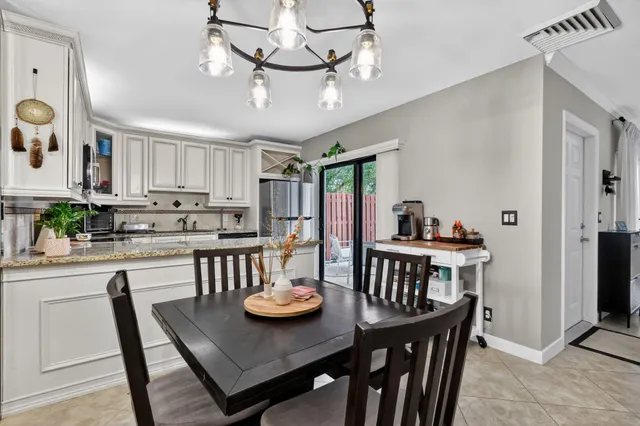 a view of a dining room with furniture a chandelier and wooden floor