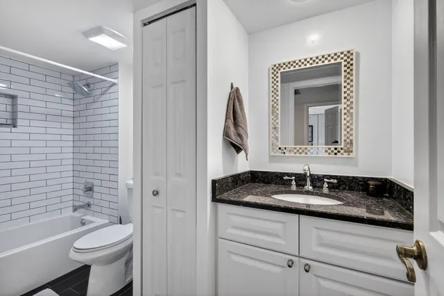 a bathroom with a granite countertop sink toilet and shower