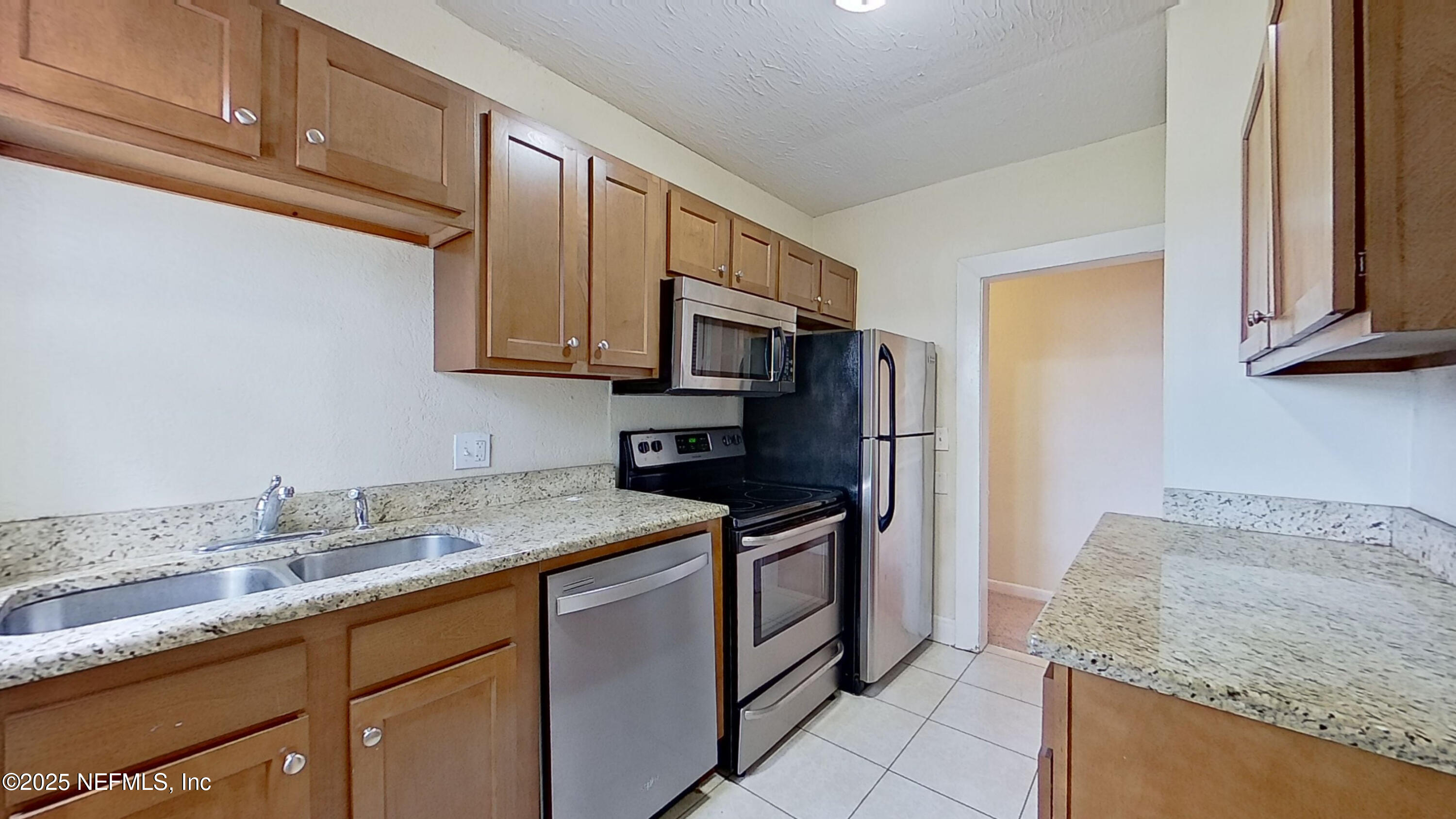 2673 Forbes Street, Unit C Jacksonville, FL 32204 - Photo 8 of 13 a kitchen with stainless steel appliances granite countertop a sink stove and refrigerator