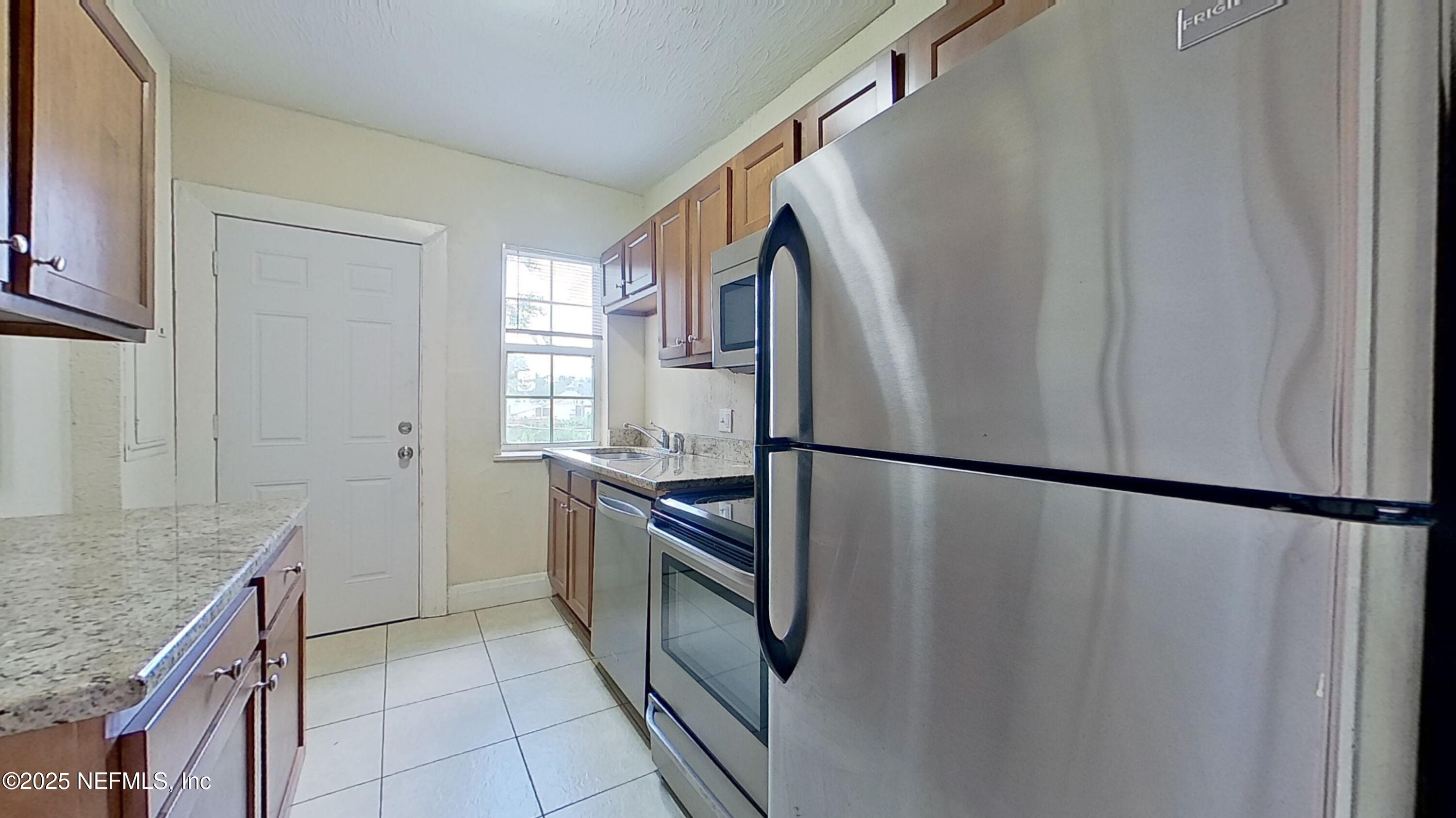 2673 Forbes Street, Unit C Jacksonville, FL 32204 - Photo 9 of 13 a kitchen with granite countertop a refrigerator and a sink