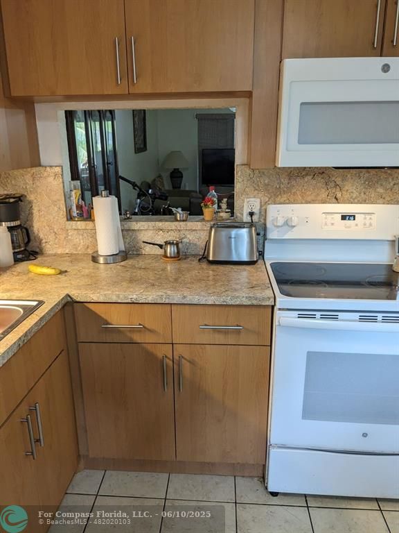 3130 Holiday Springs Boulevard, Unit 204 Margate, FL 33063 - Photo 11 of 32 a kitchen with a sink stove and cabinets