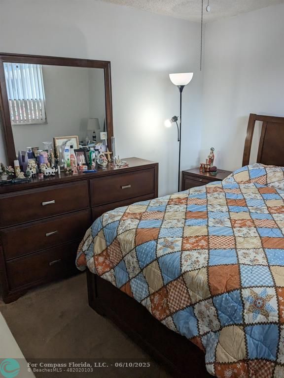 3130 Holiday Springs Boulevard, Unit 204 Margate, FL 33063 - Photo 14 of 32 a bedroom with a bed and a mirror