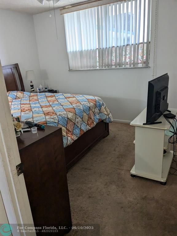 3130 Holiday Springs Boulevard, Unit 204 Margate, FL 33063 - Photo 15 of 32 a bedroom with a bed and flat tv screen on the dresser