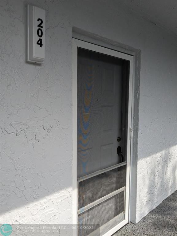 3130 Holiday Springs Boulevard, Unit 204 Margate, FL 33063 - Photo 2 of 32 a bathroom with a glass shower door